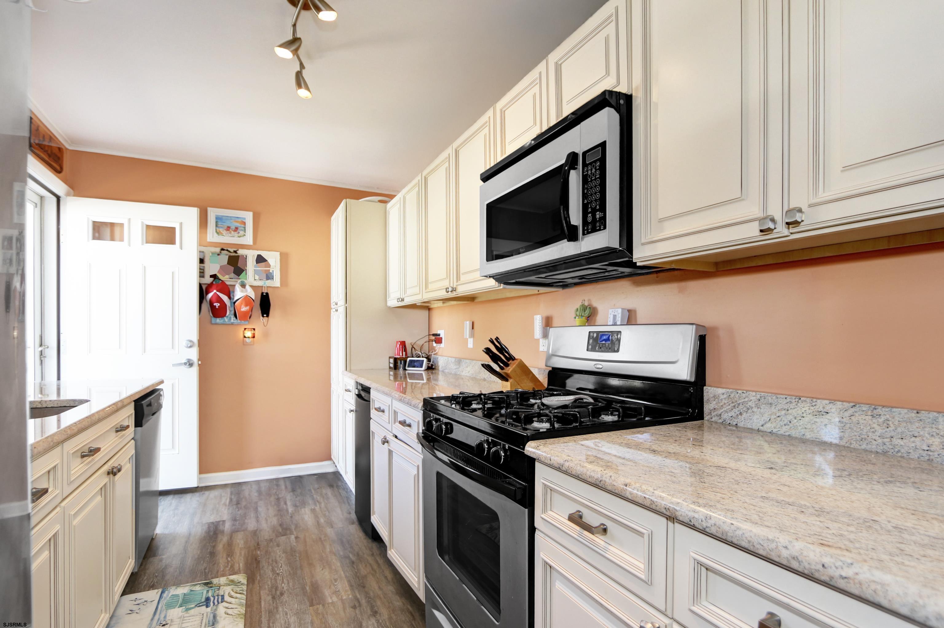 34 North Shore Road Marmora, NJ 08223 - Photo 8 of 37 a kitchen with stainless steel appliances granite countertop a stove a microwave and a refrigerator