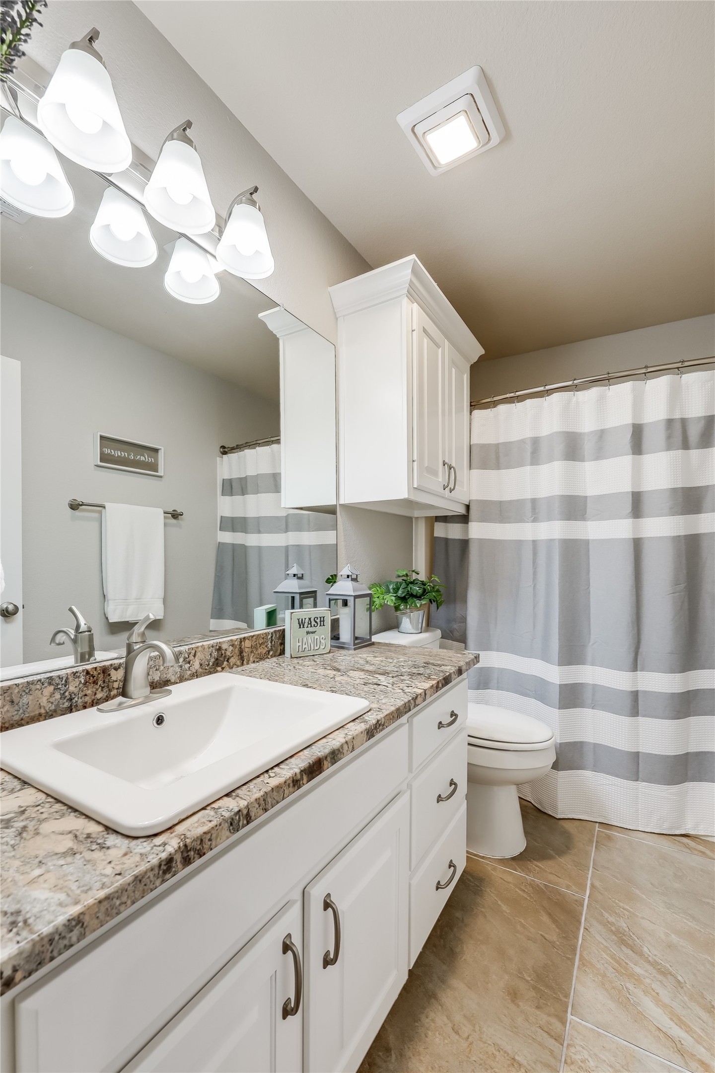 426 Summit Ridge Drive North Point Venture, TX 78645 - Photo 20 of 28 Bathroom featuring a notable chandelier, vanity, tile patterned floors, and toilet