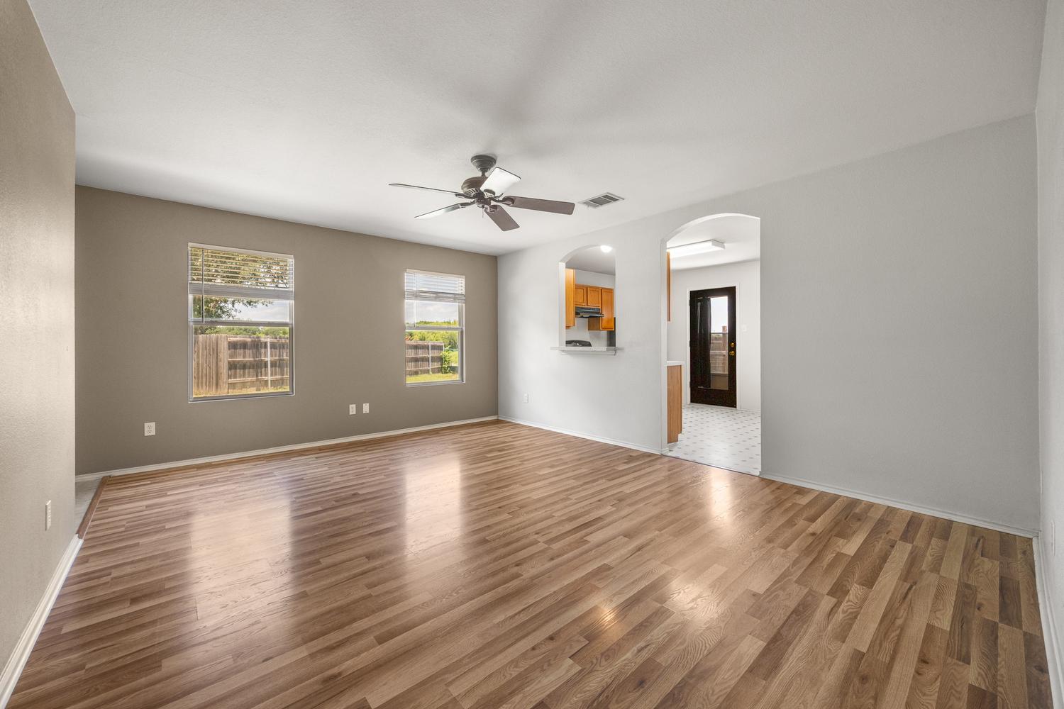 359 Spring Branch Loop Kyle, TX 78640 - Photo 4 of 17 a view of an empty room with window and wooden floor