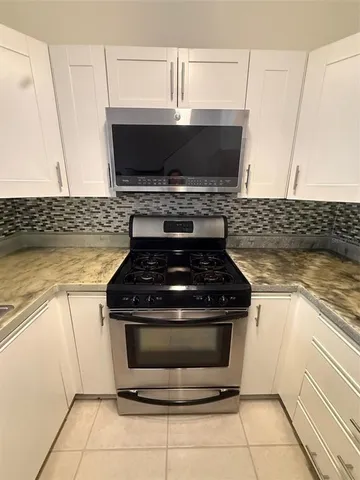 a stove top oven sitting inside of a kitchen