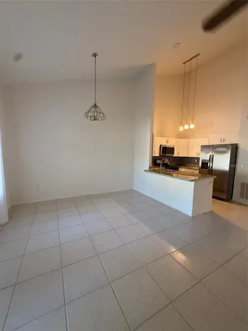 a kitchen with granite countertop a stove a sink and a refrigerator