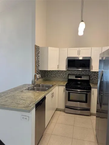 a kitchen with granite countertop a stove and a sink
