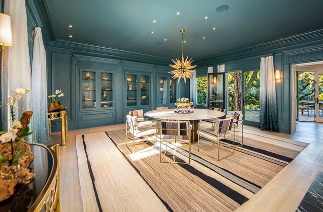 a dining room with furniture a floor to ceiling window and garden view