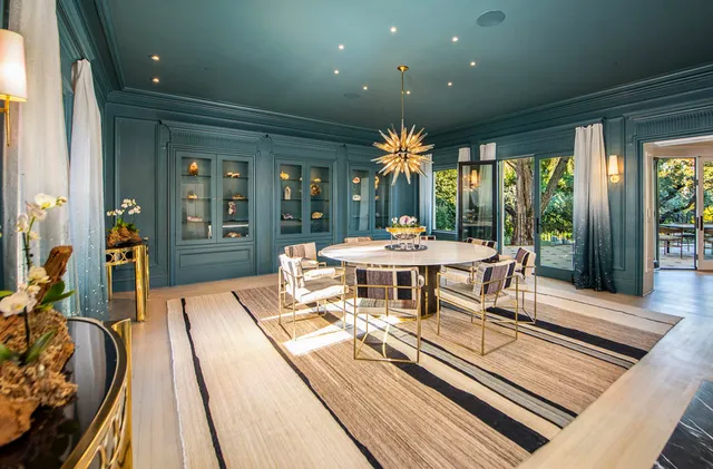 a dining room with furniture a floor to ceiling window and garden view