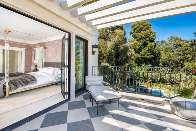 front view of house with two chairs and a potted plant