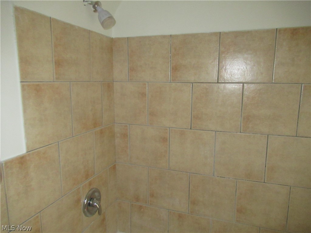 3824 East Antisdale Road Cleveland, OH 44118 - Photo 17 of 27 Tiled shower surround with neutral-toned ceramic tiles and a chrome shower fixture