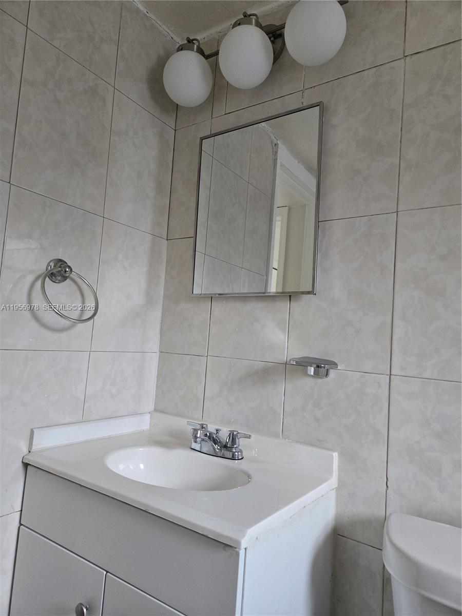 15 West 9th Street, Unit 2 Hialeah, FL 33010 - Photo 9 of 10 a bathroom with a sink a toilet and mirror
