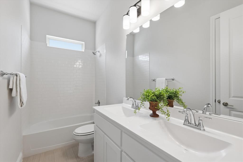 4017 Alpine Street Midlothian, TX 76065 - Photo 27 of 37 Dual vanity with integrated sinks, chrome fixtures, and a large wall-mounted mirror