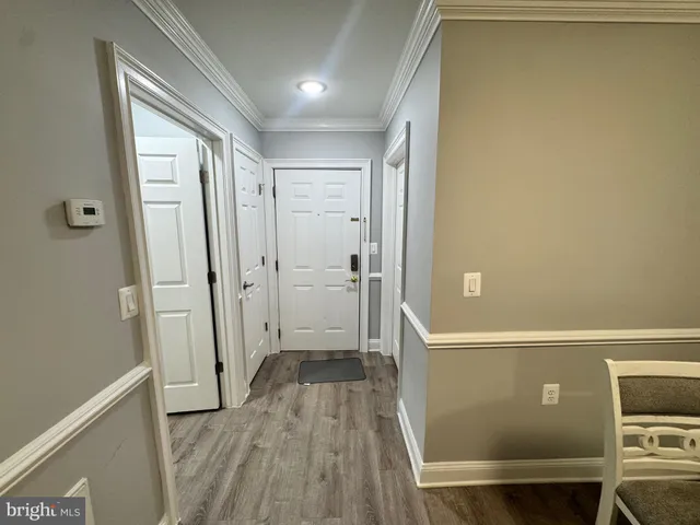 a view of a hallway with wooden floor and a cabinet