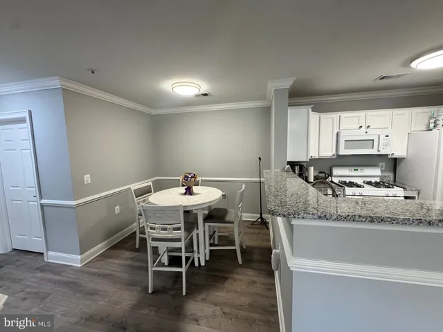 a kitchen with granite countertop sink table and chairs