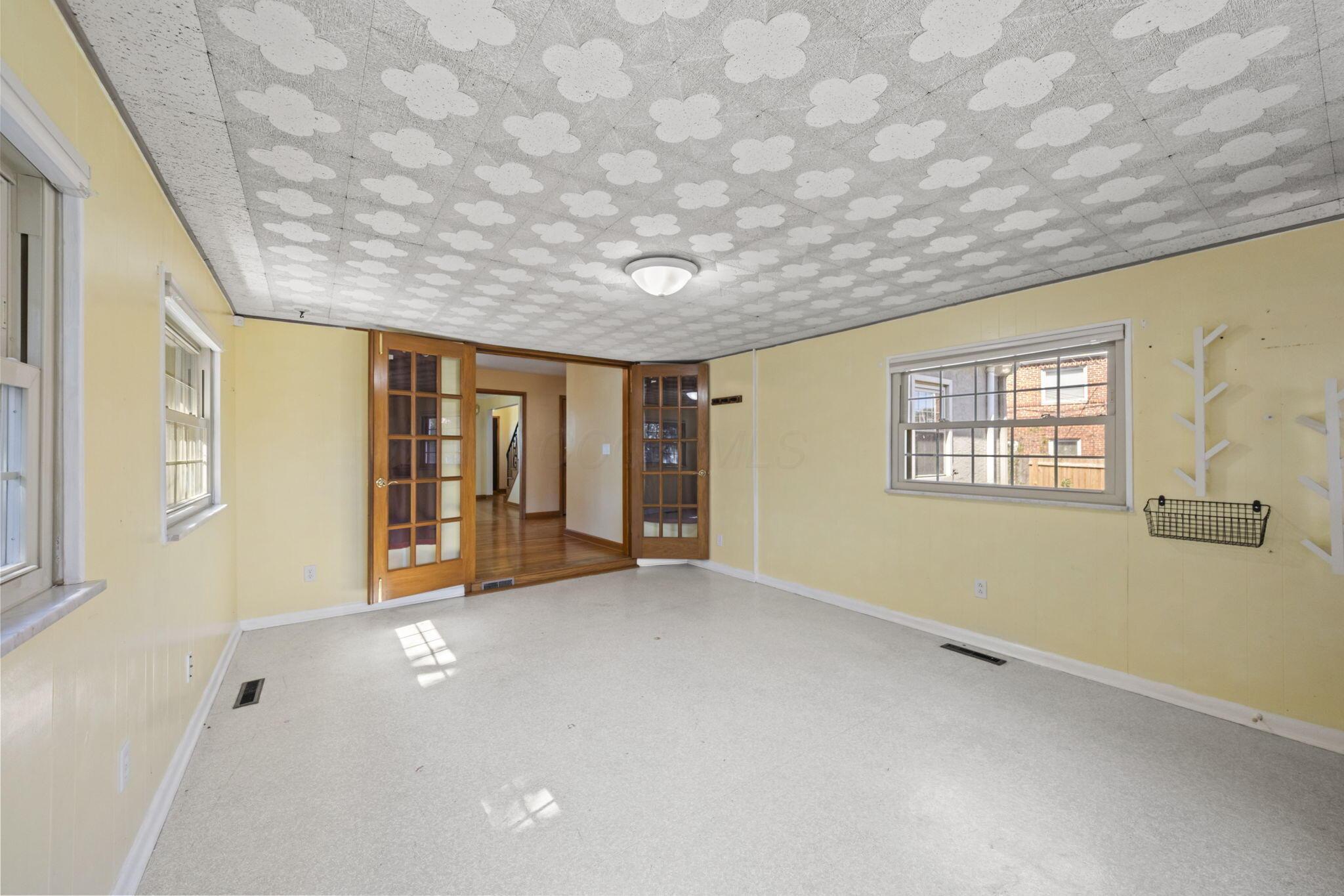 40 South Kellner Road Columbus, OH 43209 - Photo 22 of 57 Two sets of paneled French doors, multiple windows with grids, ceiling-mounted light fixture, and light-toned flooring