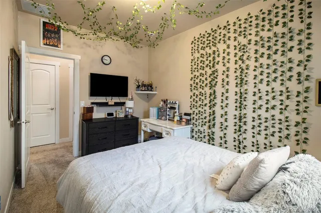 a bedroom with a bed and a flat tv screen on dresser