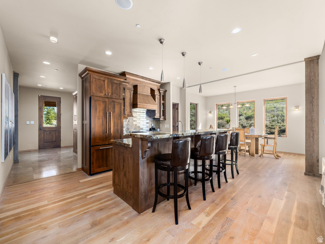 22677 East Snowbird Drive, Unit 47 Helper, UT 84526 - Photo 9 of 43 Kitchen featuring a kitchen breakfast bar, dark stone counters, a large island, pendant lighting, and light wood-style floors
