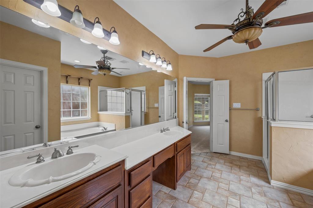 5607 Ranger Drive Rockwall, TX 75032 - Photo 23 of 40 Bathroom featuring a double vanity with wood-finish cabinetry and white countertops