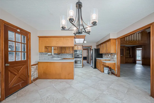 a kitchen with stainless steel appliances granite countertop a sink and a white cabinets