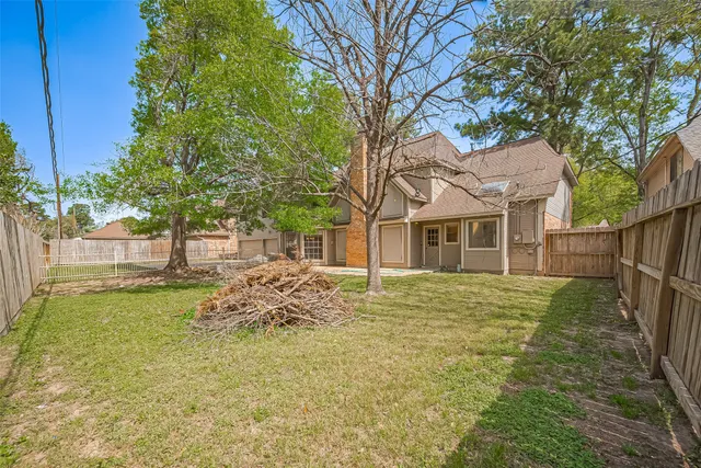 a view of a yard with wooden fence
