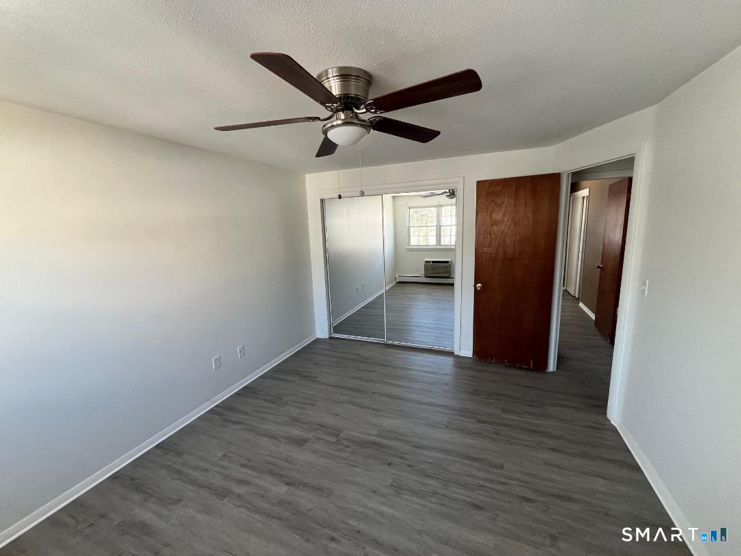 633 Center Street, Unit E Manchester, CT 06040 - Photo 11 of 15 a view of empty room with wooden floor and ceiling fan