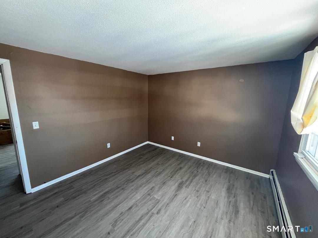633 Center Street, Unit E Manchester, CT 06040 - Photo 13 of 15 a view of room with window and wooden floor