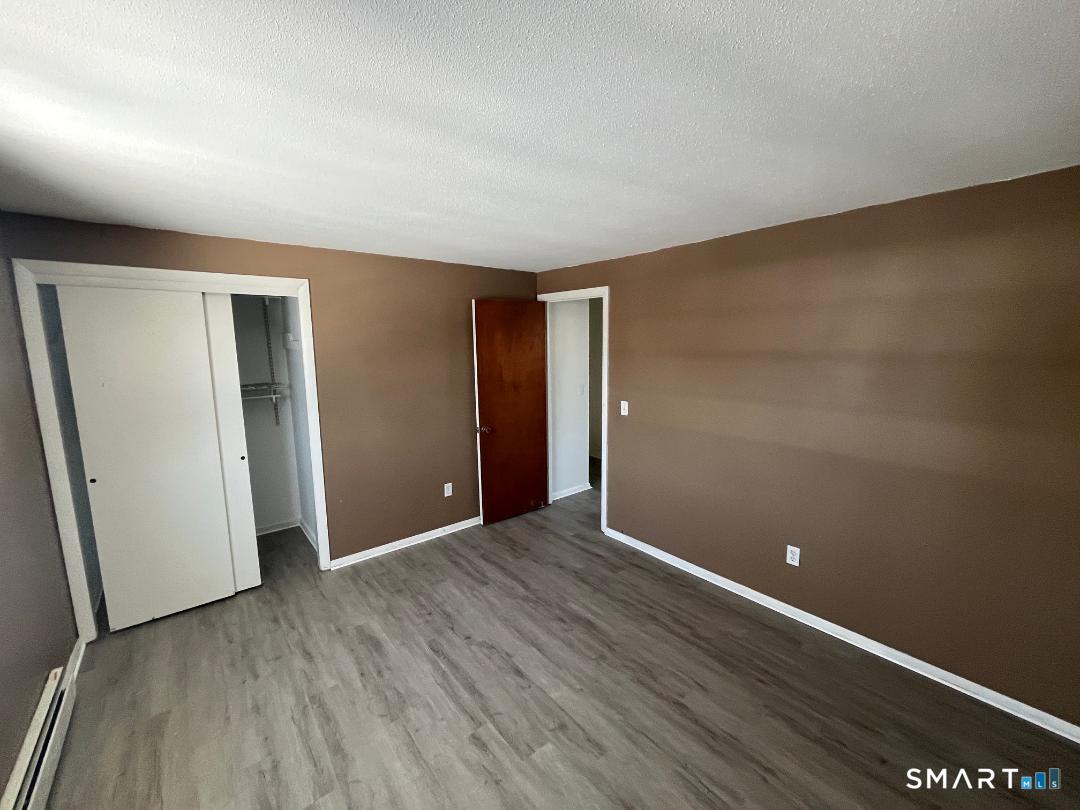 633 Center Street, Unit E Manchester, CT 06040 - Photo 14 of 15 an empty room with wooden floor and closet