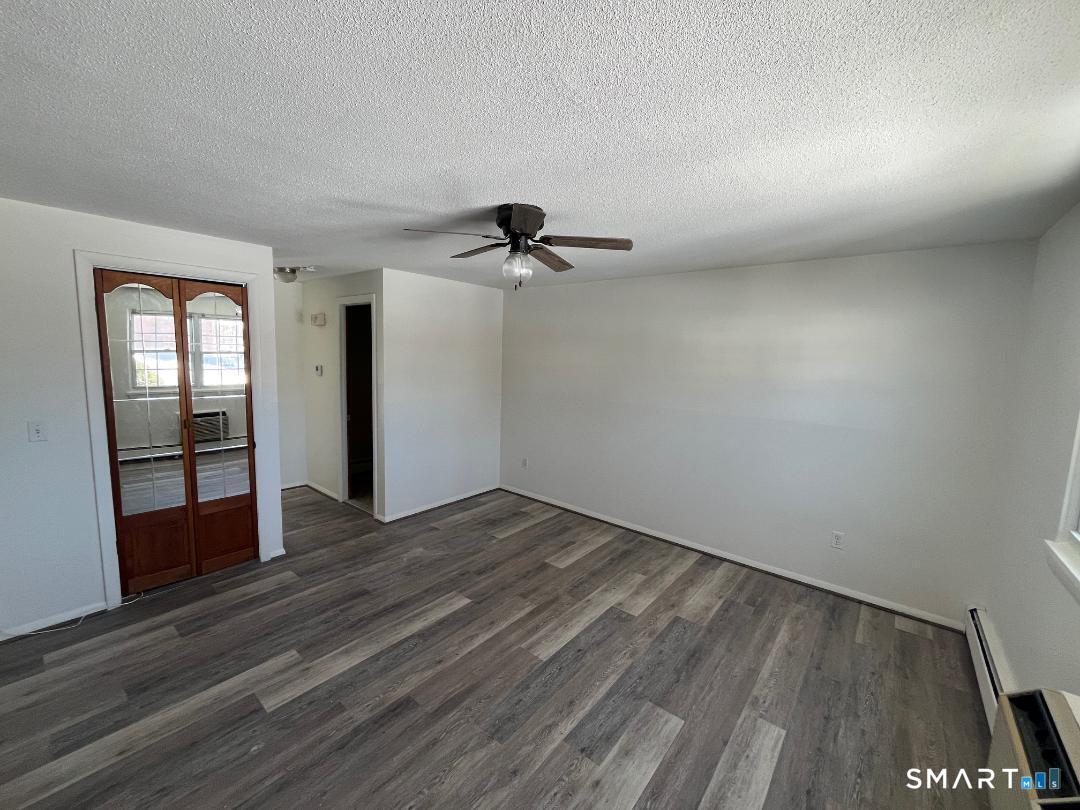 633 Center Street, Unit E Manchester, CT 06040 - Photo 3 of 15 wooden floor in an empty room with a window
