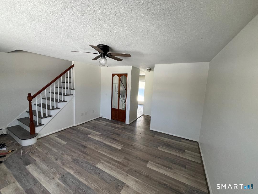 633 Center Street, Unit E Manchester, CT 06040 - Photo 4 of 15 a view of an empty room with wooden floor and stairs