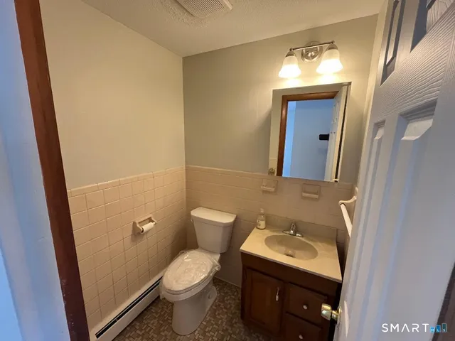 a bathroom with a sink and mirror with toilet