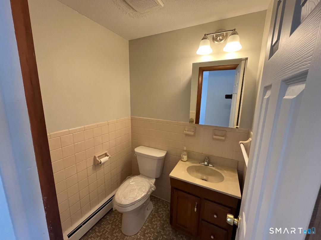 633 Center Street, Unit E Manchester, CT 06040 - Photo 5 of 15 a bathroom with a sink and mirror with toilet