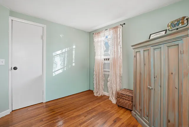 a view of a hallway with wooden floor and windows
