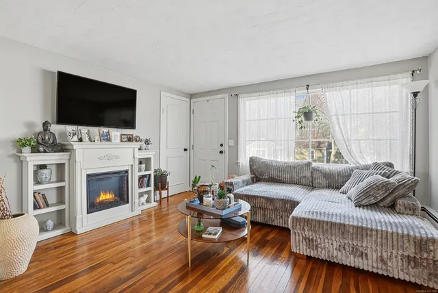 a living room with furniture a flat screen tv and a fireplace