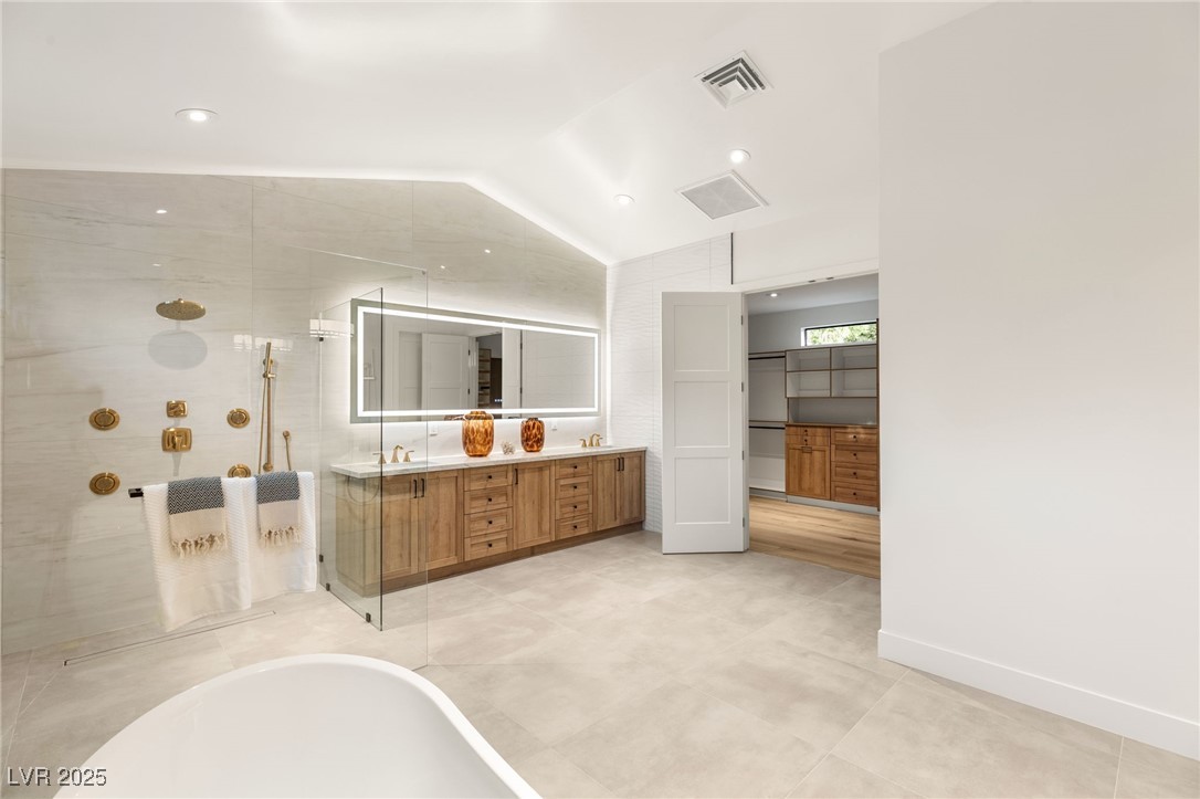 2316 Prometheus Court Henderson, NV 89074 - Photo 28 of 92 Bathroom with a freestanding tub, vaulted ceiling, visible vents, walk in shower, and double vanity