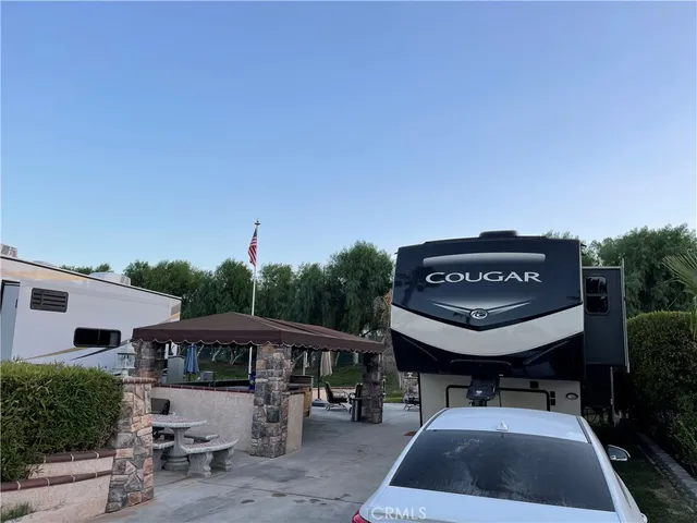 a view of a patio with table and chairs with a barbeque grill and plants