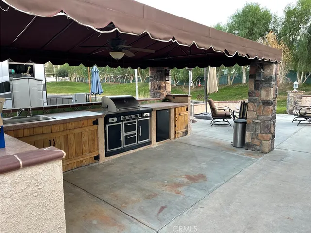 a view of a patio with a table and chairs under an umbrella