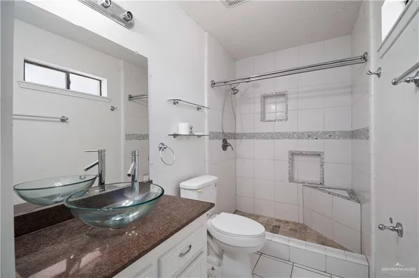 an empty room with wooden floor ceiling fan and windows