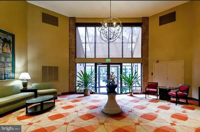 a living room with furniture a chandelier and a fireplace