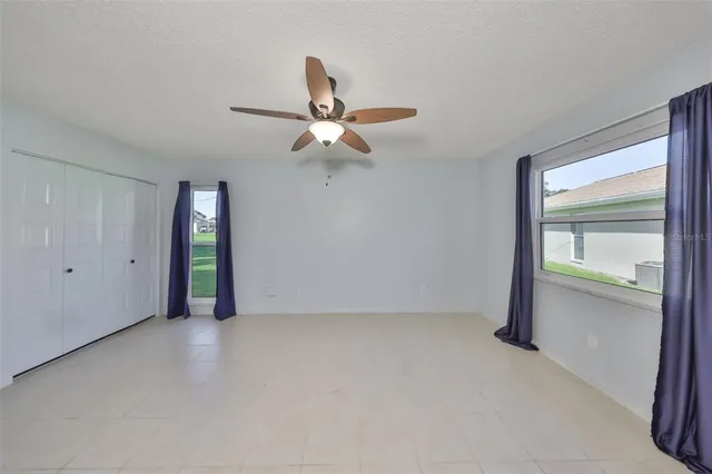 an empty room with closet and windows