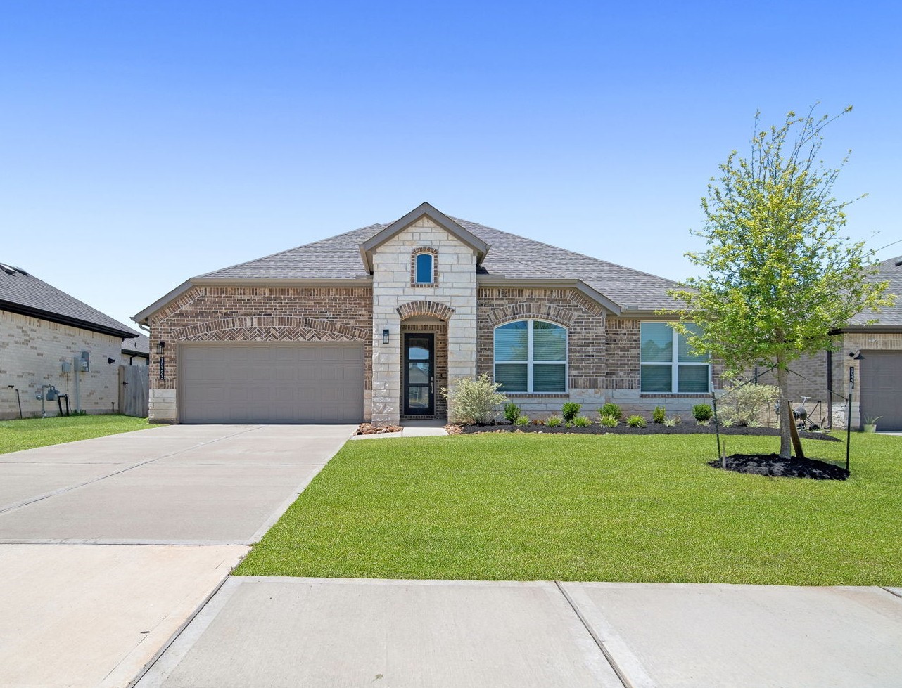a front view of a house with a garden and trees