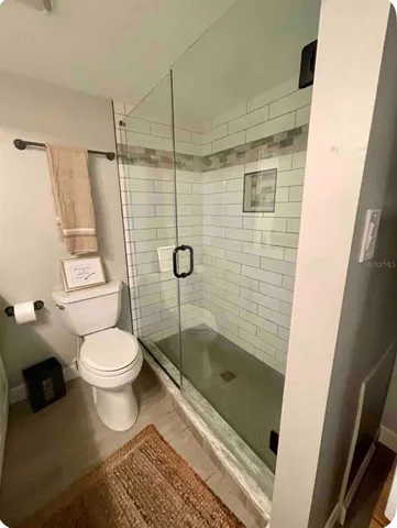 a bathroom with a toilet and a shower