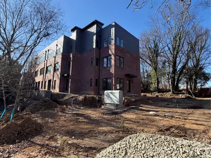 a brick building with a large tree in front