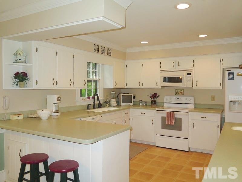 11501 Coachmans Way Raleigh, NC 27614 - Photo 6 of 20 a kitchen with a sink a stove a refrigerator and white cabinets