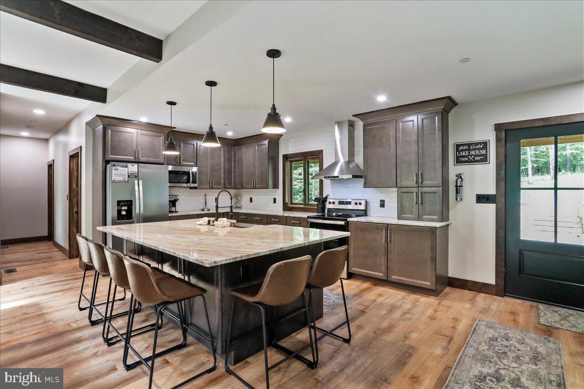 a kitchen with stainless steel appliances granite countertop a kitchen island a stove a table and chairs in it