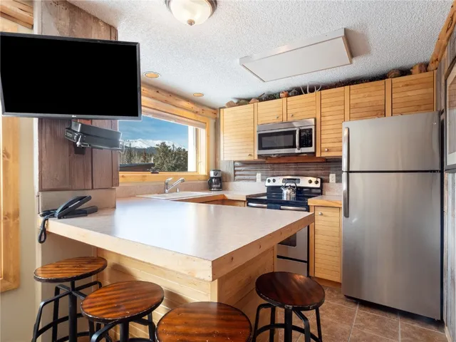 a kitchen with stainless steel appliances a stove a refrigerator and a microwave