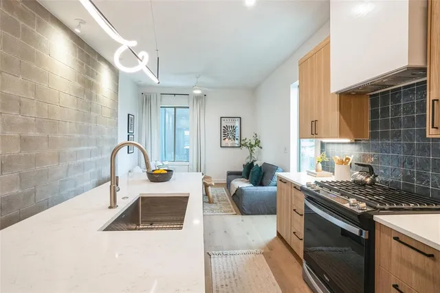 a kitchen with a sink a stove and cabinets