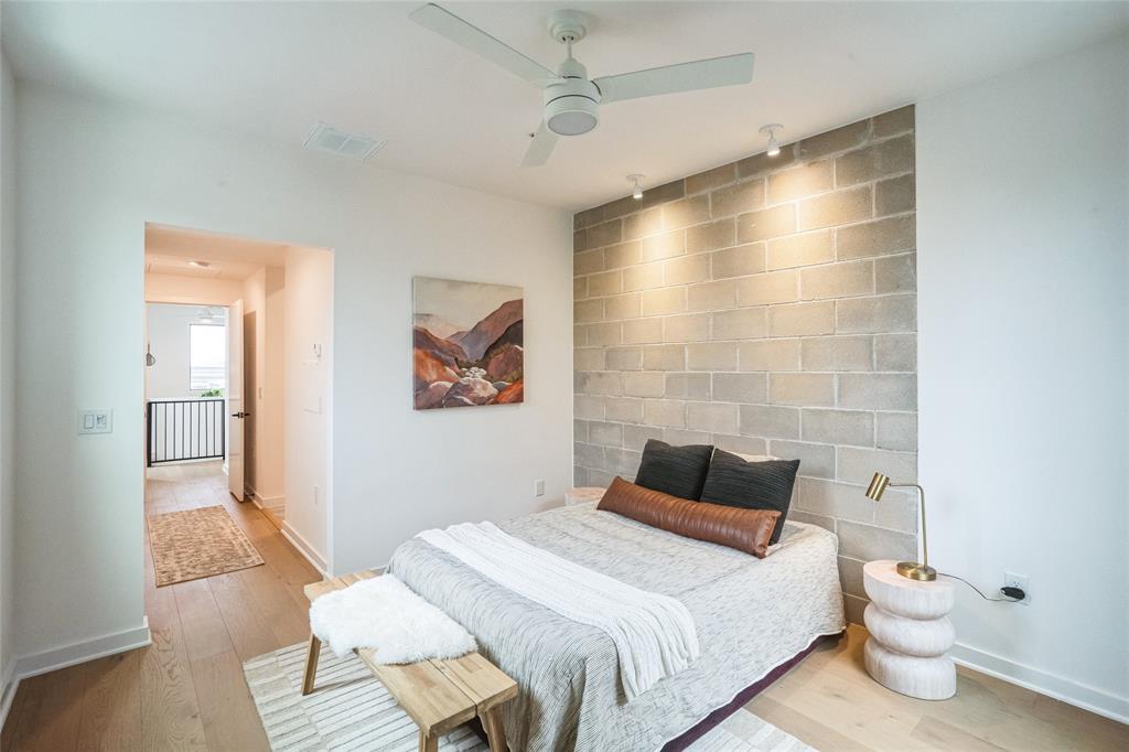 700 Denson Drive, Unit 1102 Austin, TX 78752 - Photo 13 of 30 a bedroom with a bed and a wall painting