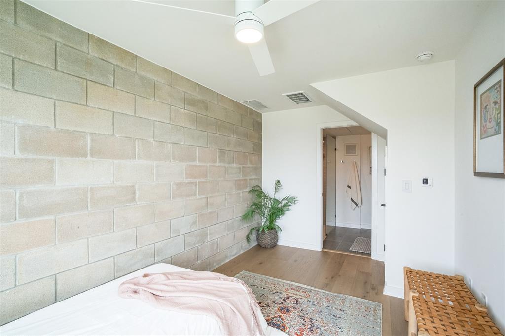 700 Denson Drive, Unit 1102 Austin, TX 78752 - Photo 18 of 30 a bedroom with a bed and a potted plant