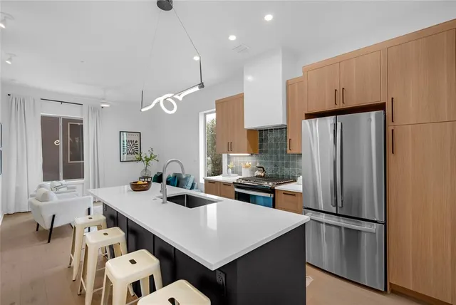 a kitchen with a refrigerator a stove a sink dishwasher with a dining table and chairs