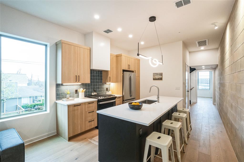 700 Denson Drive, Unit 1102 Austin, TX 78752 - Photo 5 of 30 a kitchen that has a lot of cabinets a sink and appliances in it