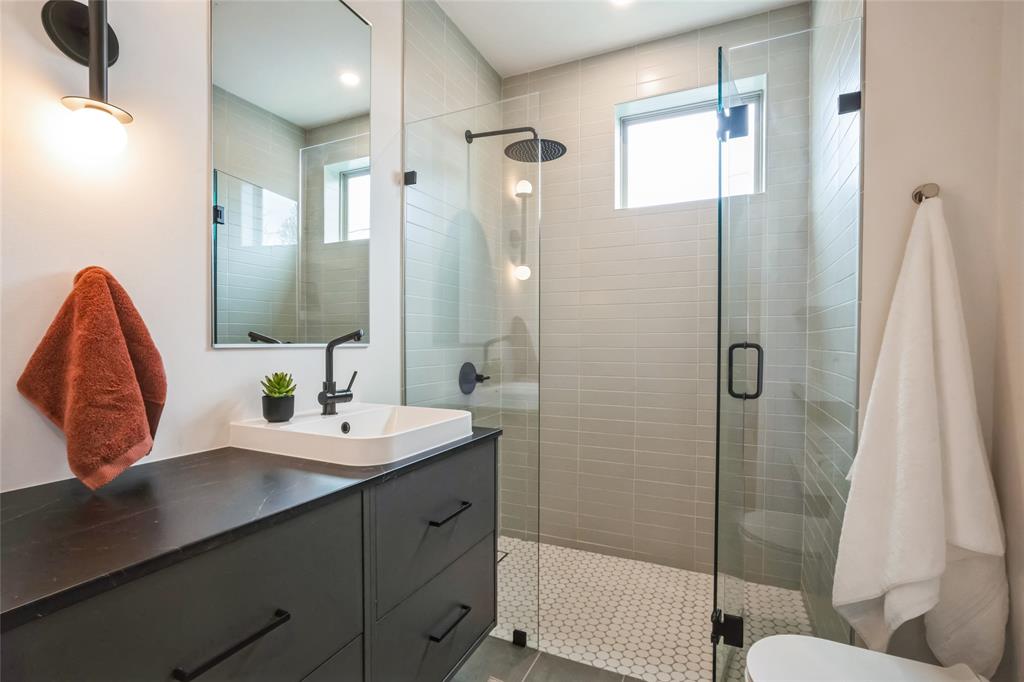 700 Denson Drive, Unit 1102 Austin, TX 78752 - Photo 7 of 30 a bathroom with a double vanity sink toilet and shower