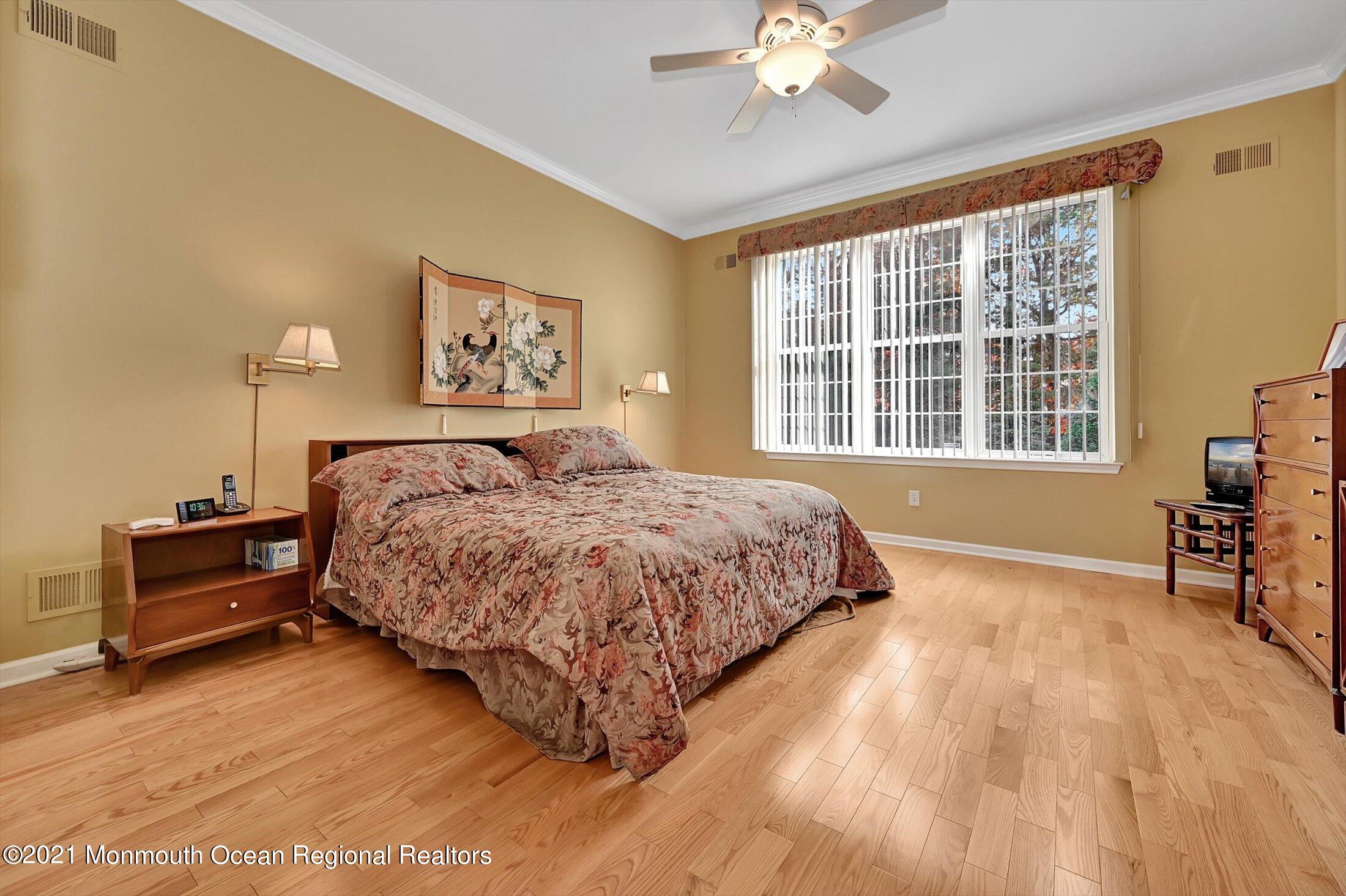 65 Crooked Stick Road Jackson, NJ 08527 - Photo 22 of 51 a spacious bedroom with a large bed and a chandelier