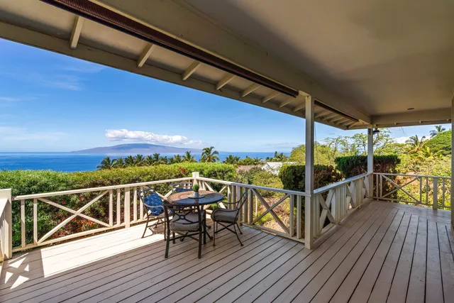 a view of a balcony with chairs and wooden floor