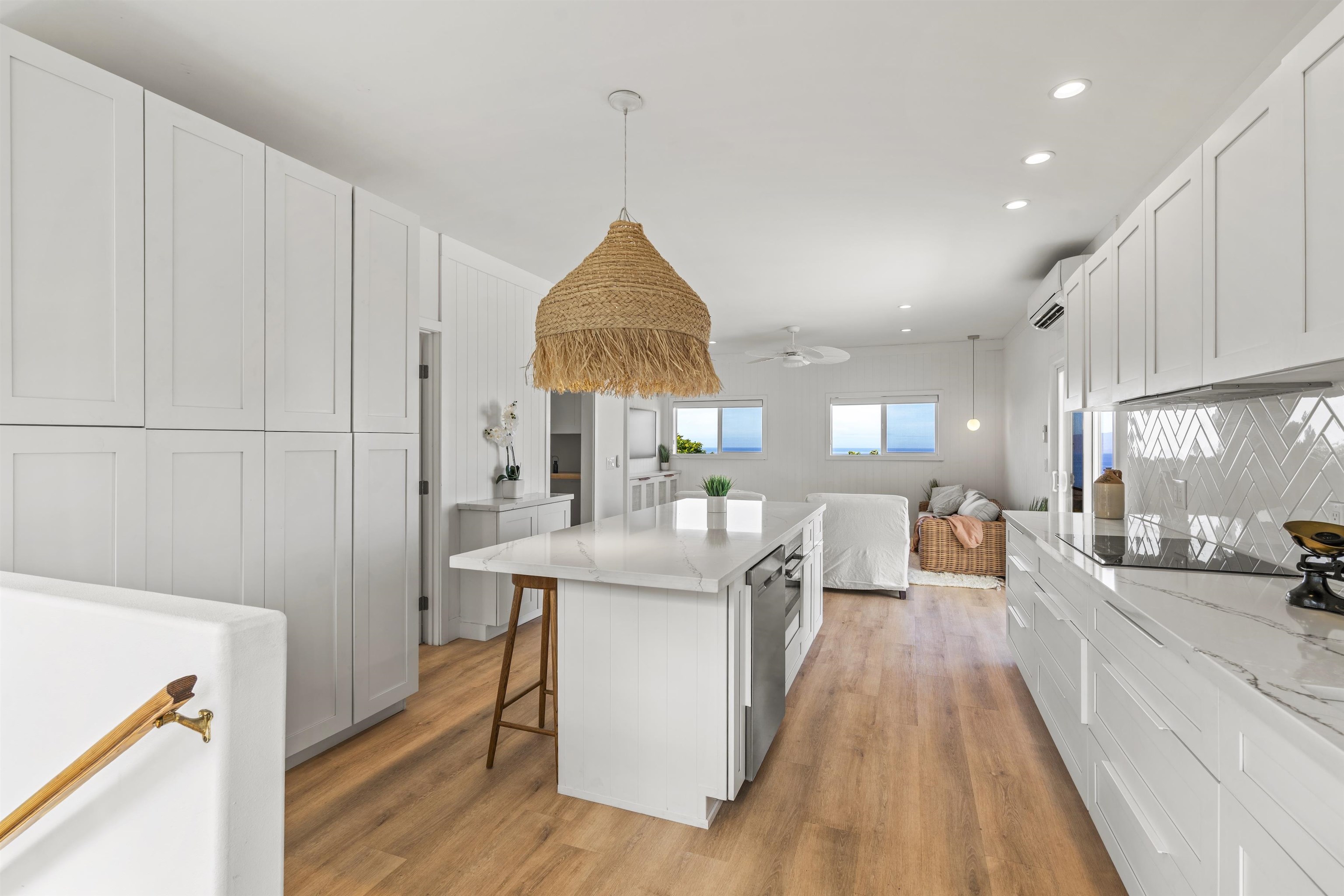 60 East Huapala Place, Unit B Lahaina, HI 96761 - Photo 36 of 50 a view of a kitchen with kitchen island a counter top space a sink a stove and a wooden floors